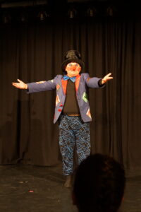 Ein Schüler, verkleidet als Clown, steht auf der Bühne