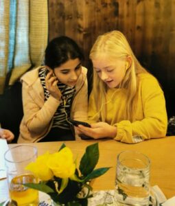 Zwei junge Mädchen schauen sich etwas am Handy an